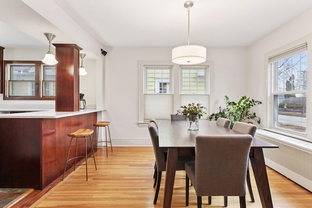 dining space featuring light wood-style floors and baseboards