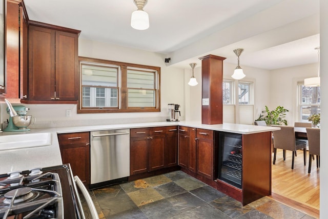 kitchen with dishwasher, wine cooler, a peninsula, light countertops, and a sink