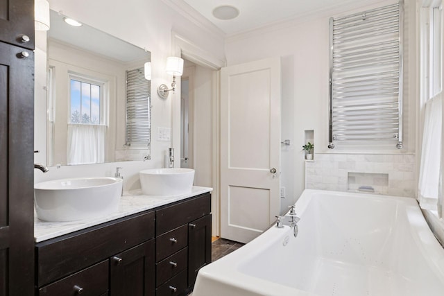 bathroom featuring crown molding, a garden tub, a sink, and radiator heating unit