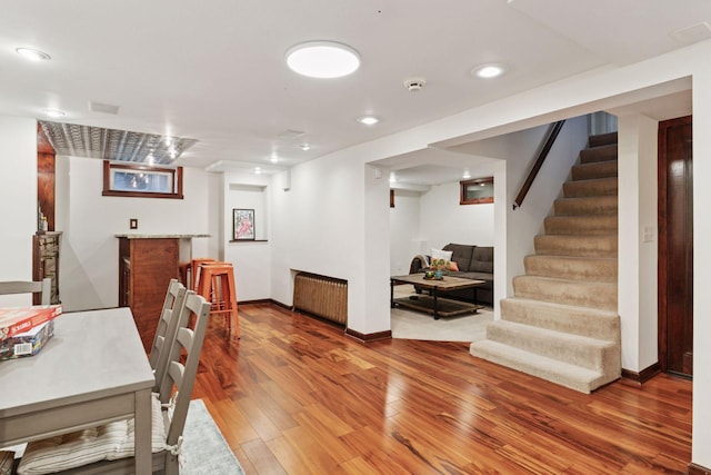 dining space featuring recessed lighting, stairway, radiator heating unit, wood finished floors, and baseboards