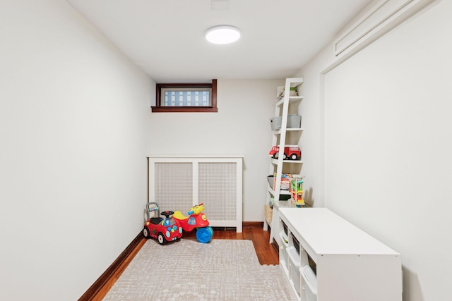 playroom with baseboards and wood finished floors