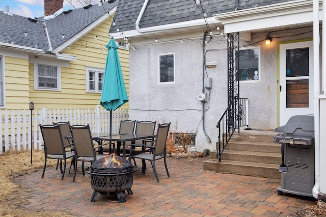 view of patio / terrace with a fire pit, outdoor dining area, area for grilling, and fence