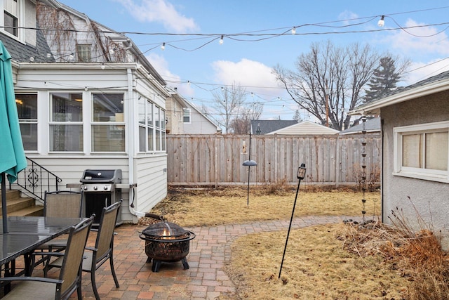 view of patio featuring a fire pit, fence, and grilling area