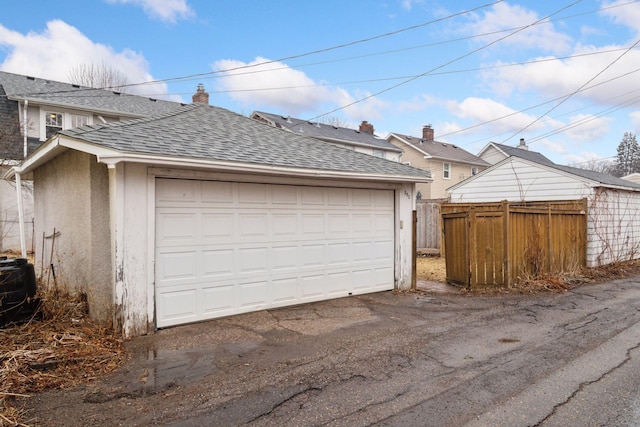 detached garage featuring fence and central air condition unit