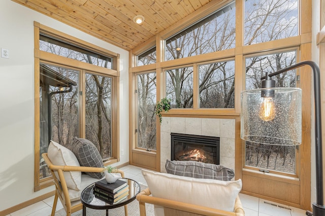 sunroom / solarium featuring wood ceiling, visible vents, and a tile fireplace