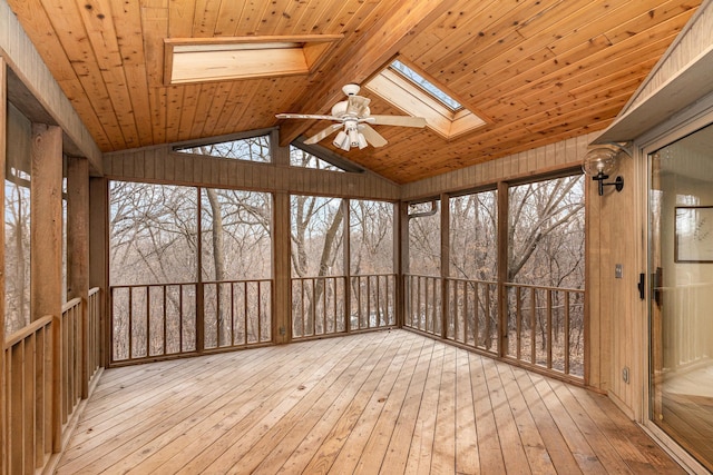 unfurnished sunroom with lofted ceiling with skylight, a ceiling fan, and wooden ceiling