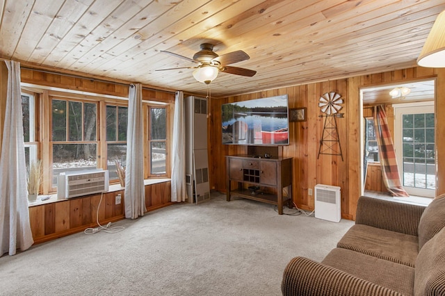 living room featuring light carpet, cooling unit, a healthy amount of sunlight, and wood walls