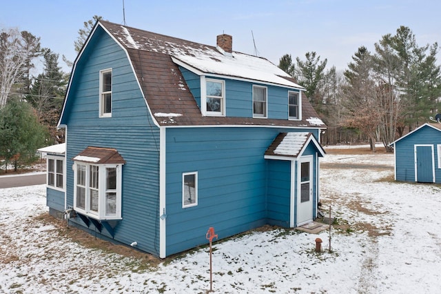 snow covered property featuring a storage unit