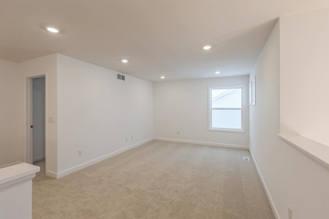 unfurnished room featuring light carpet