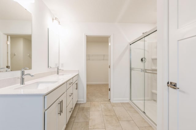 bathroom featuring a shower with door, tile patterned floors, and vanity