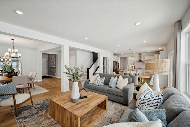 living room with an inviting chandelier and light wood-type flooring