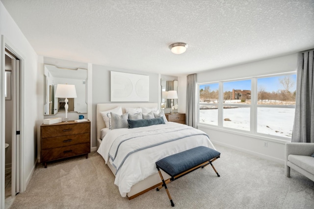 bedroom featuring light carpet and a textured ceiling