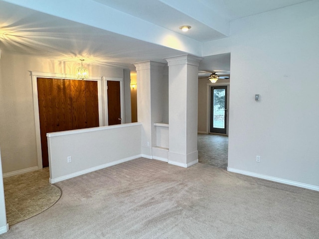 spare room featuring carpet and ceiling fan with notable chandelier