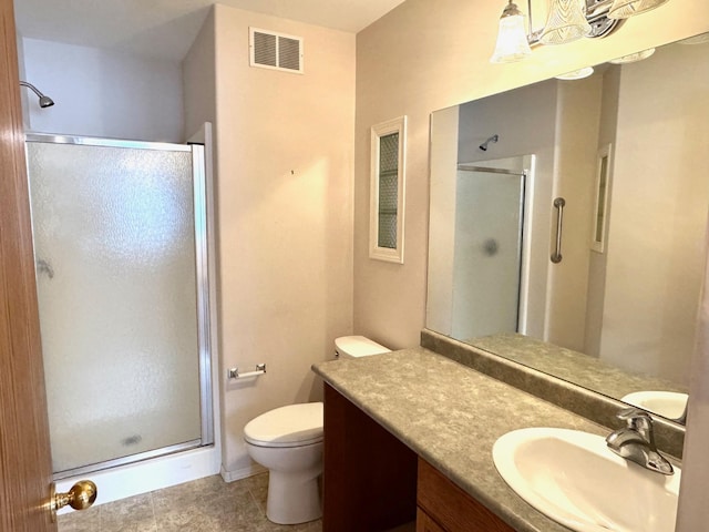 bathroom featuring toilet, tile patterned flooring, vanity, and walk in shower