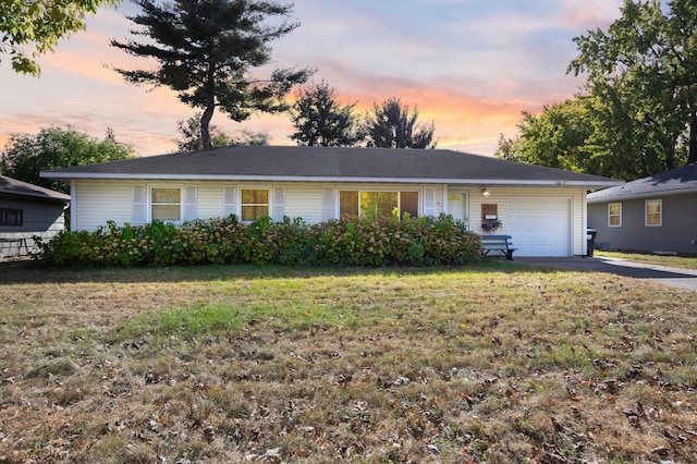 ranch-style house featuring a yard and a garage