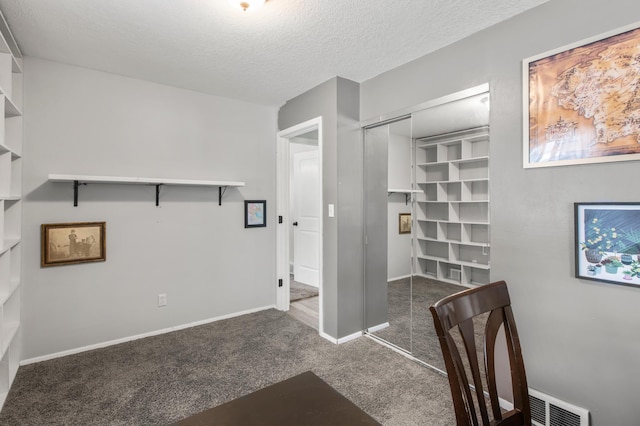 unfurnished office with a textured ceiling and dark carpet