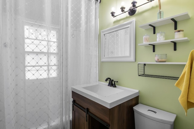 bathroom featuring a shower with curtain, vanity, and toilet