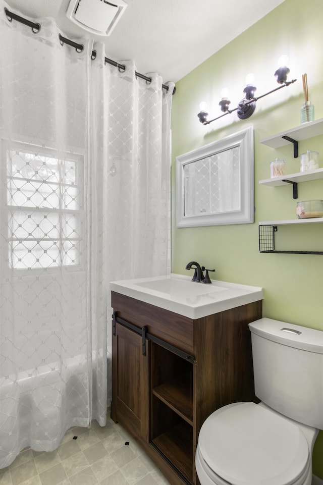 full bathroom featuring vanity, shower / tub combo, and toilet