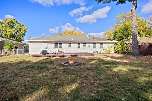 back of house featuring a deck, a yard, an outdoor fire pit, and central AC