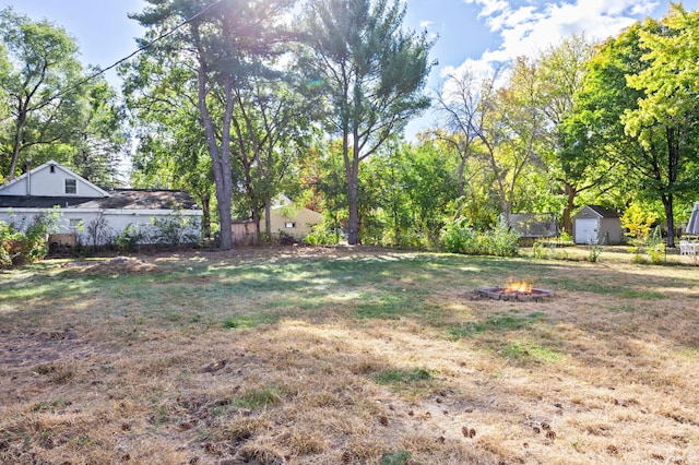 view of yard featuring a shed and an outdoor fire pit