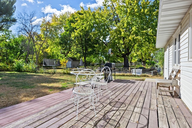 wooden deck featuring a lawn and a trampoline