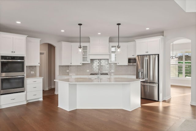 kitchen featuring decorative light fixtures, decorative backsplash, white cabinetry, and appliances with stainless steel finishes