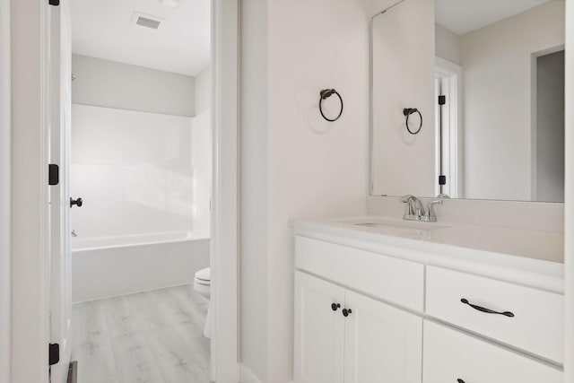 full bathroom featuring vanity, toilet, wood-type flooring, and shower / tub combination