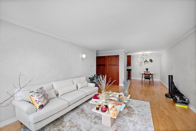 living room with a chandelier, hardwood / wood-style floors, and crown molding