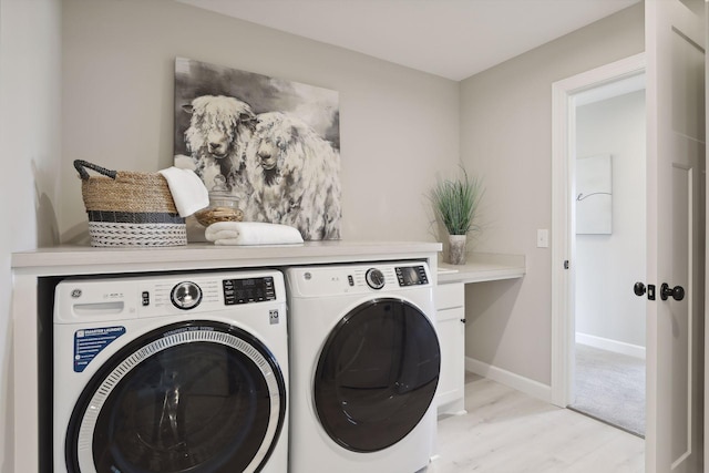 clothes washing area with washer and clothes dryer and light hardwood / wood-style floors