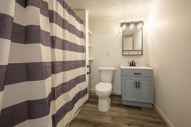 bathroom featuring vanity, hardwood / wood-style flooring, toilet, a textured ceiling, and walk in shower