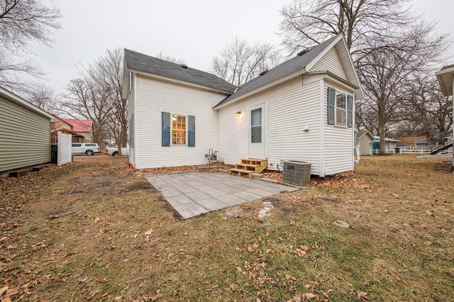 rear view of property featuring central air condition unit, a patio, and a yard