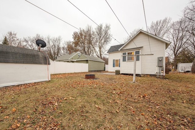 rear view of property featuring an outdoor fire pit