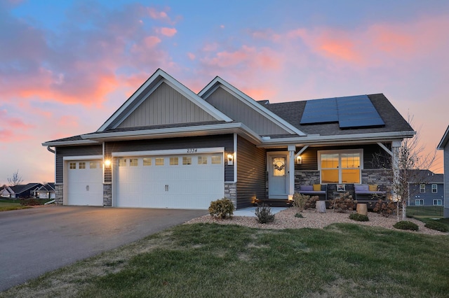 craftsman inspired home featuring a garage, a lawn, and solar panels