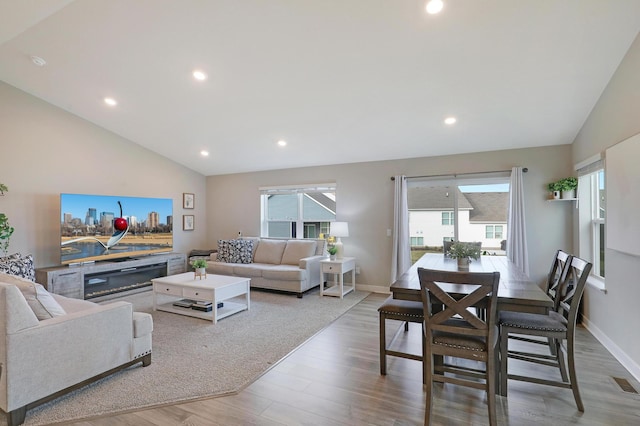 living room with lofted ceiling, hardwood / wood-style floors, and a wealth of natural light