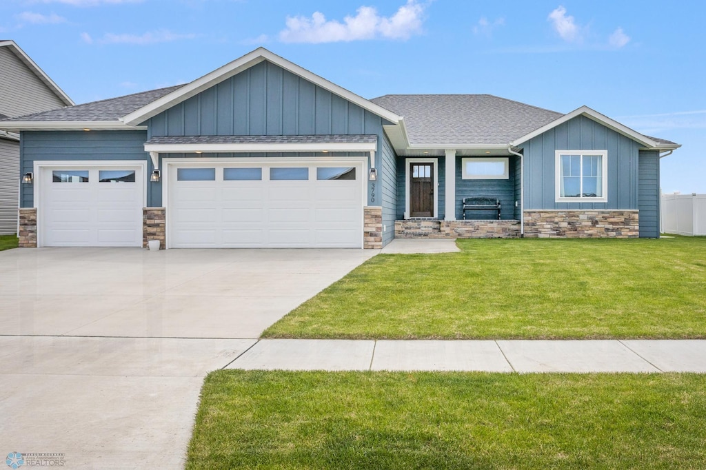 craftsman inspired home featuring a garage and a front lawn