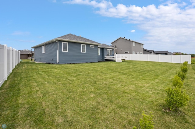 back of property with a wooden deck and a yard