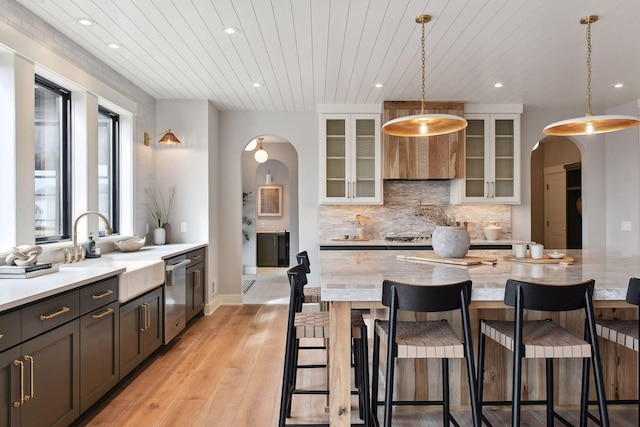 kitchen featuring appliances with stainless steel finishes, light wood-type flooring, sink, wooden ceiling, and hanging light fixtures