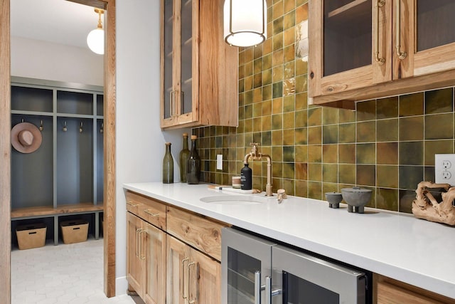 kitchen featuring backsplash, light tile patterned floors, sink, and beverage cooler