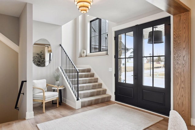 foyer entrance featuring french doors and light hardwood / wood-style floors