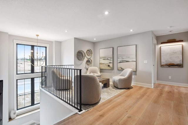 living room featuring light wood-type flooring and a notable chandelier