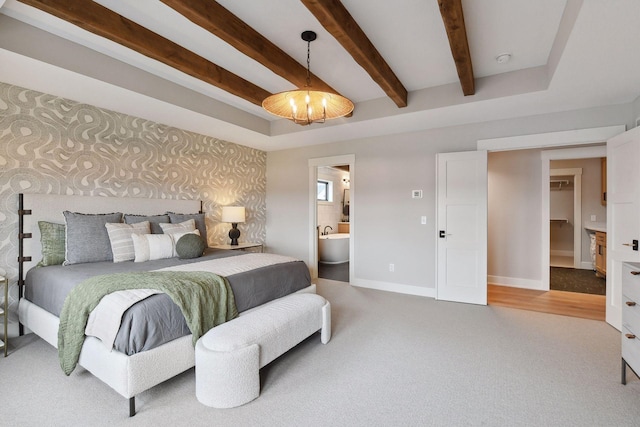 bedroom featuring connected bathroom, carpet, and a notable chandelier