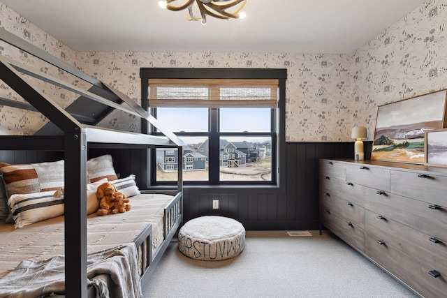 bedroom with carpet floors and wood walls