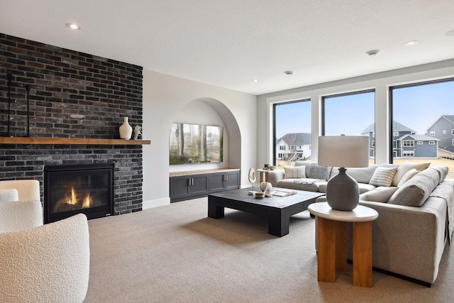 living room with light carpet, a fireplace, and a textured ceiling