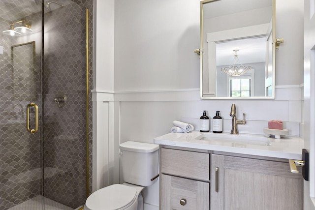 bathroom featuring toilet, vanity, a chandelier, and walk in shower