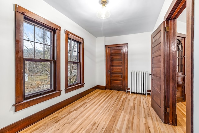 unfurnished room with light hardwood / wood-style floors and radiator