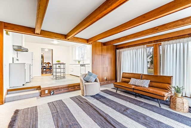 living room with beam ceiling, sink, and a baseboard heating unit