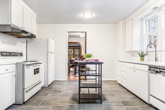 kitchen featuring white appliances, white cabinetry, and sink