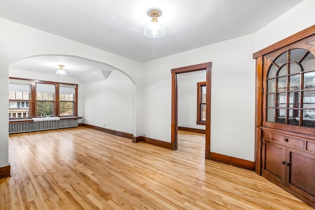 unfurnished dining area with light wood-type flooring and radiator