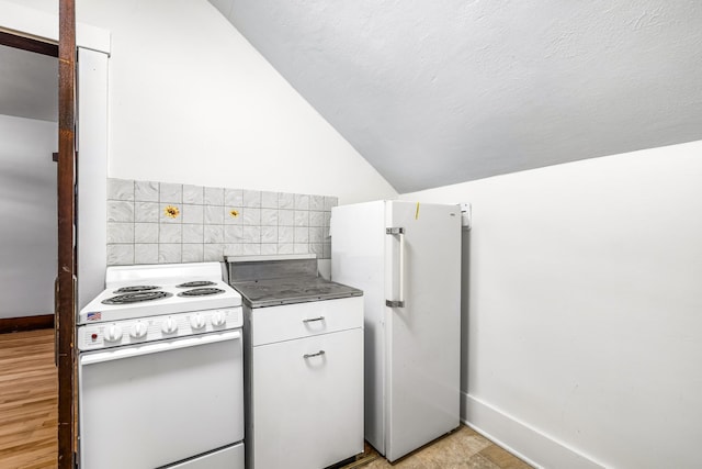 kitchen featuring vaulted ceiling, tile walls, white cabinetry, and white appliances