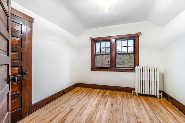 interior space with radiator heating unit, light hardwood / wood-style floors, and lofted ceiling